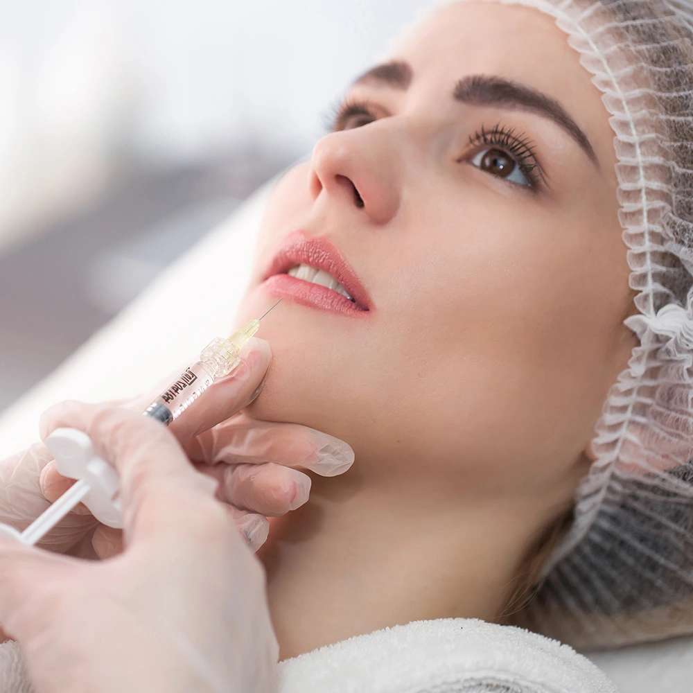 Young woman receiving dermal filler injections for facial volume and rejuvenation